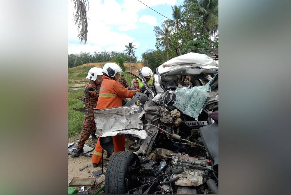 Rescue personnel in their efforts to take out the victims in the vehicle involved in the accident at KM46 Kampung Selamat, Sungai Tong, Setiu on Saturday. - Photo by firemen.