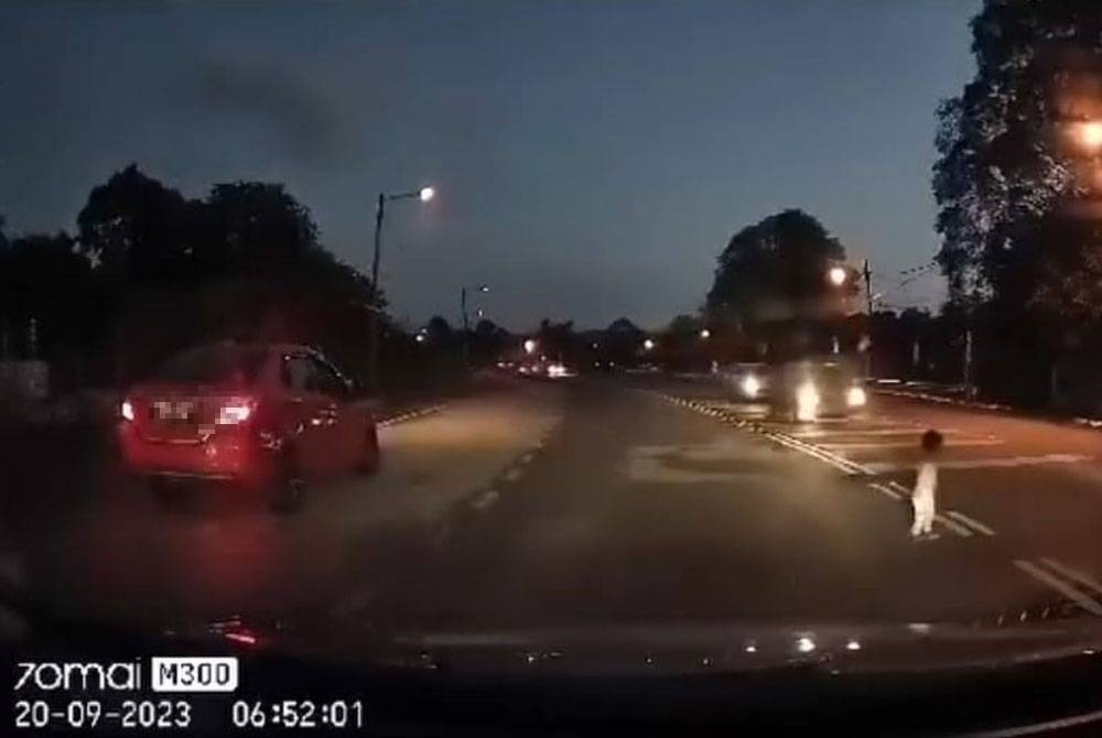Screenshot of a viral video showing a two-year-old girl almost being run over while crossing the road alone on Jalan Melaka Pindah last Wednesday.