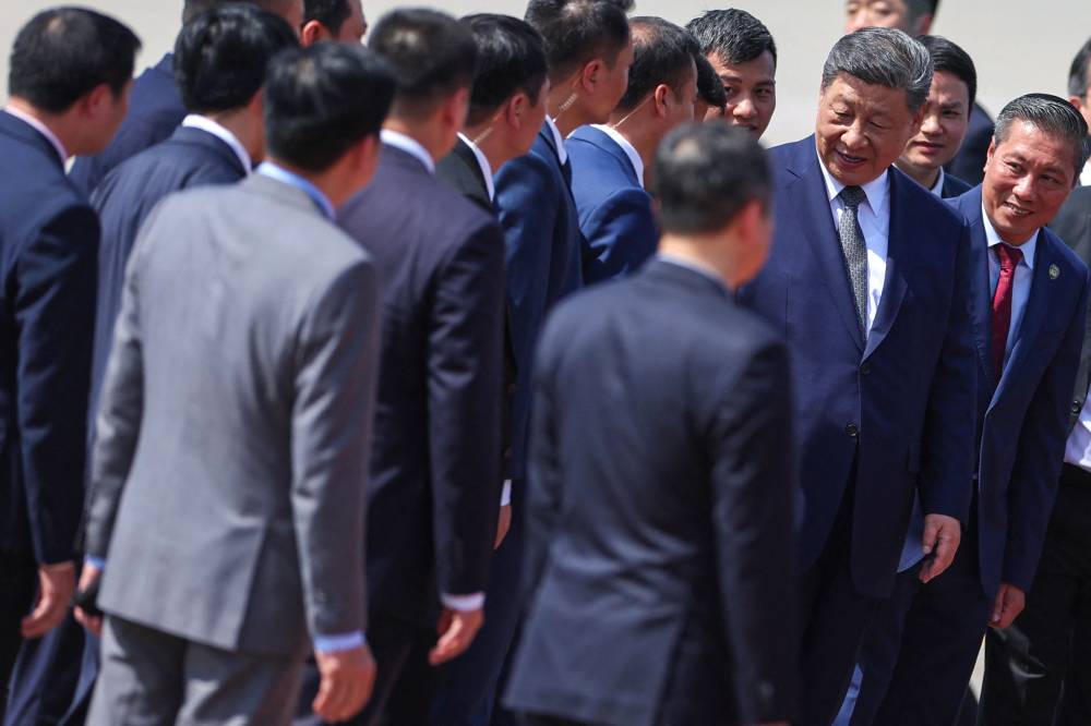 Chinese President Xi Jinping (2R) leaves to board his plane for departure following his visit to Vietnam at Noi Bai International Airport in Hanoi on April 15, 2025. Xi is in Vietnam as part of a Southeast Asia tour that will include Malaysia and Cambodia, with Beijing trying to position itself as a stable alternative to Trump as leaders confront US tariffs. (Photo by Athit Perawongmetha / POOL / AFP)