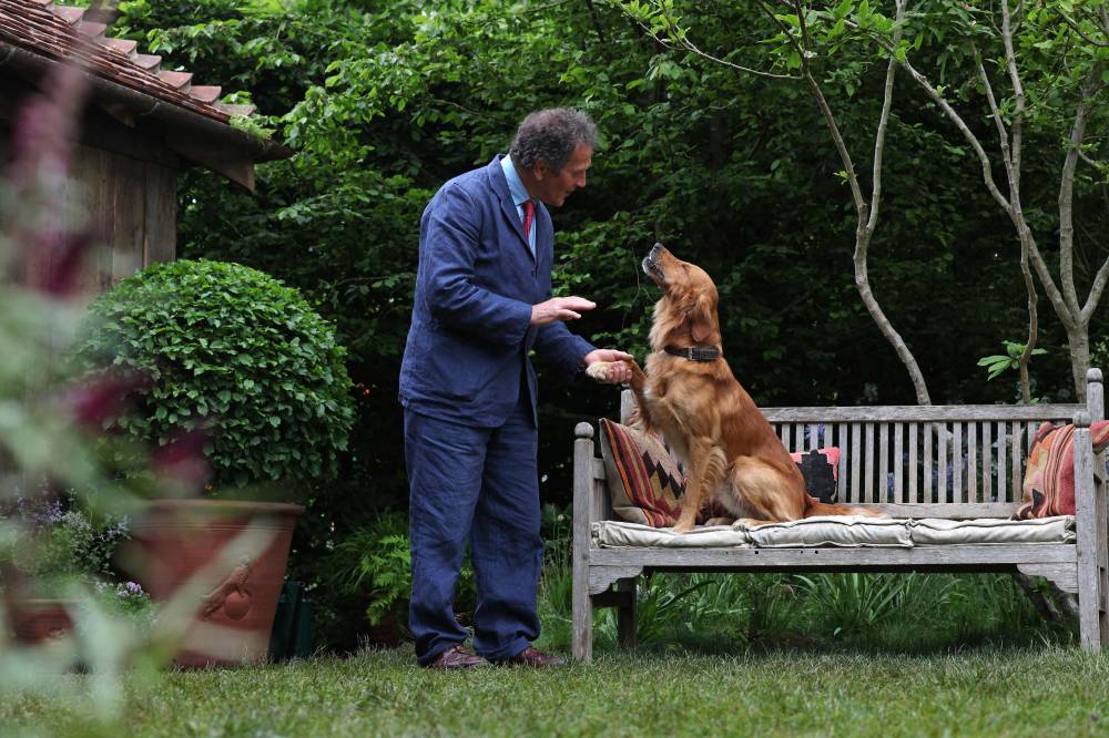 Gardener Monty Don poses with his dog Ned, a Golden Retriever, in his dog-friendly garden on May 19, 2025. Photo by Adrian Dennis/AFP