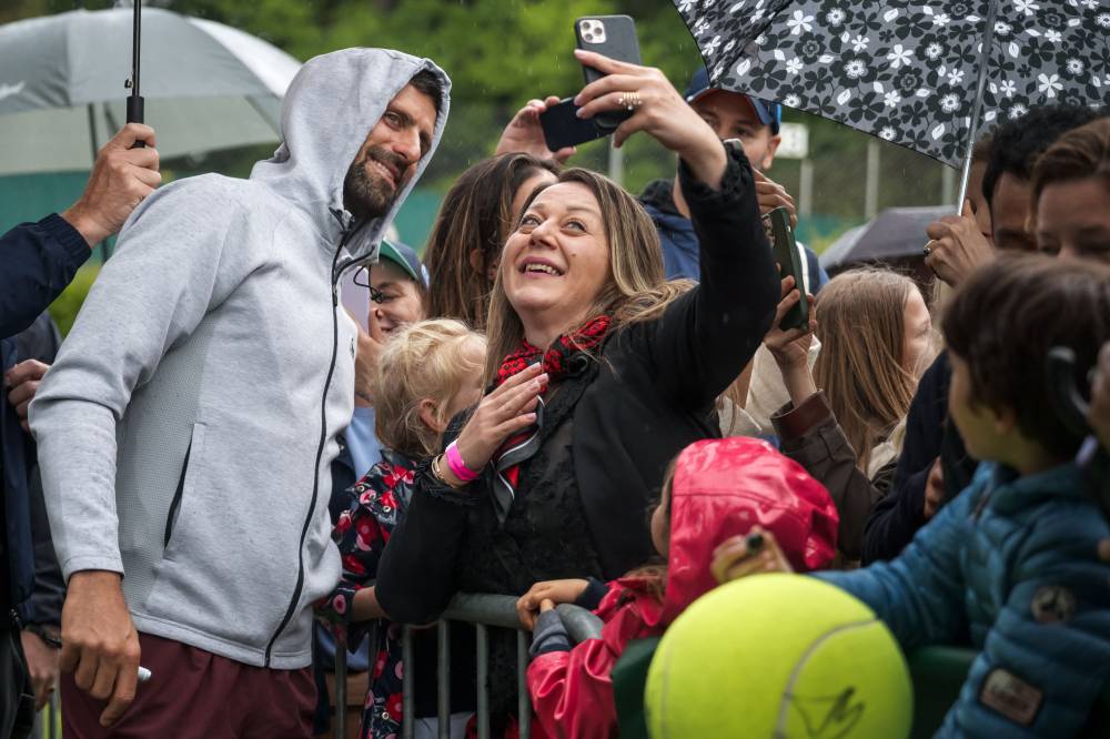 Serbia's Novak Djokovic takes a selfie with fans after a training session at the ATP 250 Geneva Open tennis tournament in Geneva on May 20, 2025. (Photo by FABRICE COFFRINI / AFP)
