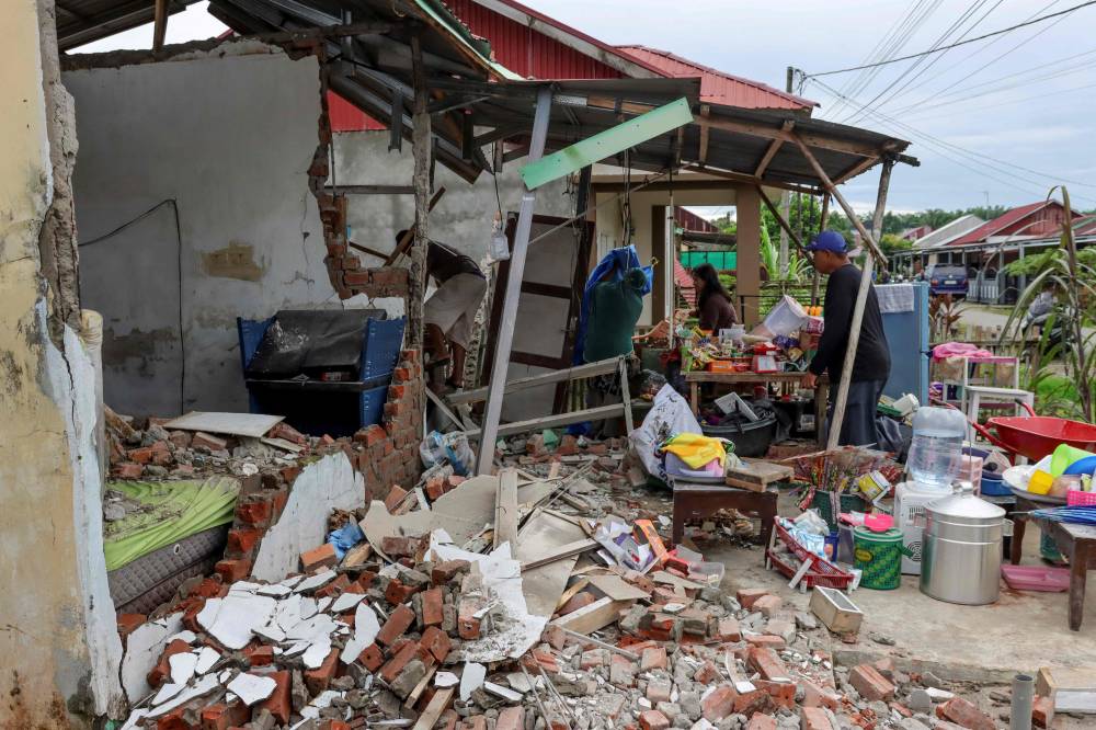 Residents search for valuables from the rubble of their damaged homes by the 6.3-magnitude earthquake at Betungan urban village, Bengkulu Province on May 23, 2025, which also damaged dozens of other houses and buildings with no casualties reported so far. Photo by AFP