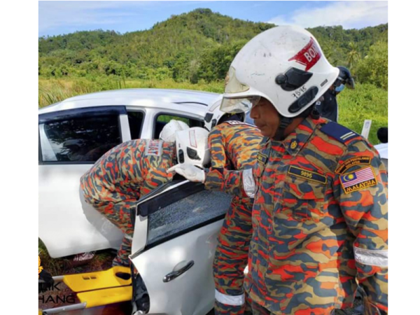Anggota bomba dari Balai Bomba dan Penyelamat (BBP) Gebeng membantu mengeluarkan mayat mangsa yang tersepit dalam kemalangan di Kilometer 164.Jalan Kuantan-Kemaman Foto IHSAN BOMBA
