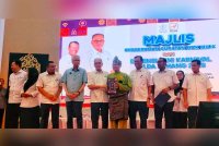 Wan Rosdy (lima dari kiri) menyerahkan surat hak milik kepada peneroka Felda Triang 3 pada Isnin.