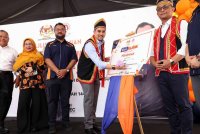 Asyraf Wajdi menandatangani plak khas pada perasmian UNI Klinik Metrocity di Kuching pada Selasa. Foto: Bernama